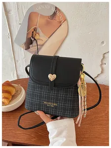 Chic plaid crossbody bag for women featuring heart clasp and tennis racket charm.
