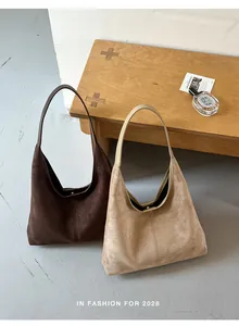 Nahaufnahme von zwei Retro-Wildleder-Hobo-Taschen in Braun und Beige im Maillard-Stil
