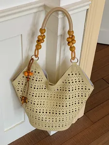 Chic beige hollowed-out geometric pattern tote bag featuring decorative wooden bead handles