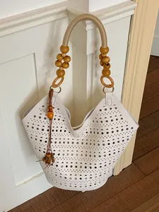Bohemian style white laser-cut tote bag with chic wooden bead handles and tassel