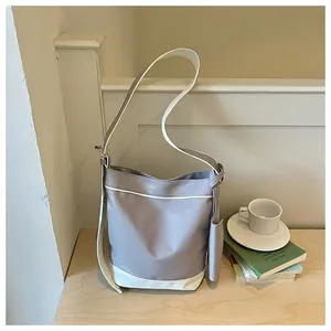 Stylish grey and white canvas tote bag shown in a lifestyle scene on a wooden table