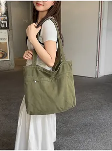 Vista dettagliata di borsa tote in tela verde oliva con tasca a cerniera funzionale