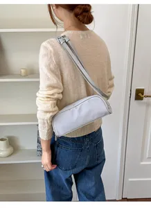 Detailed back view of a woman wearing a stylish light gray nylon crossbody bag.