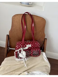 Close-up detail of the red polka-dot vintage shoulder bag with heart pendant