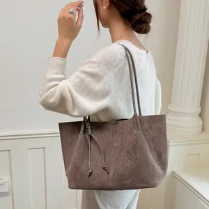 Side view of woman wearing large brown suede tote bag, minimalist vintage shoulder bag