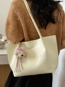 Cream minimalist women's tote bag with a cute bear charm, perfect for summer commute