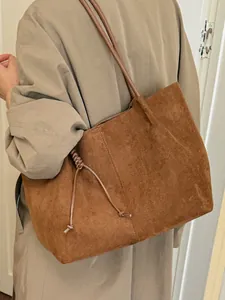 Stylish large vintage brown suede commuter tote bag for women worn on shoulder.