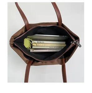 Vue interne du grand sac cabas en nylon marron avec ordinateur portable et livres
