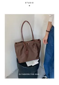 Grand sac cabas léger en nylon marron pour femme présenté sur un piédestal noir
