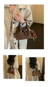 Detailansicht einer braunen geflochtenen Eimertasche mit einem süßen Teddybär-Anhänger