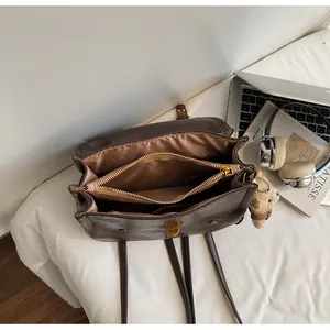Interior detail of a brown soft leather backpack showing multiple compartments and zipper pocket