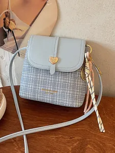 Small light blue checkered crossbody bag featuring heart buckle and tassel charm