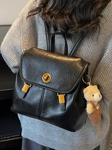 Minimalist black soft leather backpack for women featuring gold-tone turn-lock and cute bear