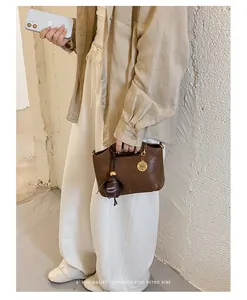 Minimalist retro brown leather handbag for women shown in a casual lifestyle setting