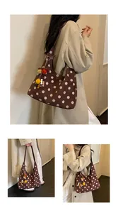 Detailed views of a brown suede hobo bag with white polka dots and a cute pom-pom charm