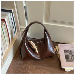 Minimalistische dunkelbraune glänzende Hobo-Tasche aus Kunstleder mit Perlenanhänger