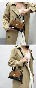 Detailed view of a brown and black quilted handbag styled with a classic beige trench coat