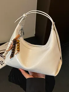 Cremefarbene Hobo-Tasche mit bunten Perlen-Anhängern in moderner Optik und Leder-Textur