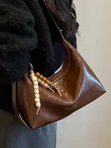 Moderne dunkelbraune Leder Hobo Schultertasche mit dekorativem Perlenanhänger
