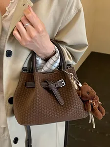 Elegante retro braune Handtasche mit Webmuster und einem süßen Plüschbären-Anhänger