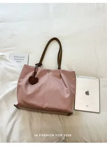 Vue détaillée du sac cabas en nylon rose à côté d'un iPad pour l'échelle