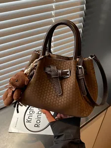 Klassische braune gewebte Beuteltasche mit süßem Bärenanhänger und verstellbarem Riemen