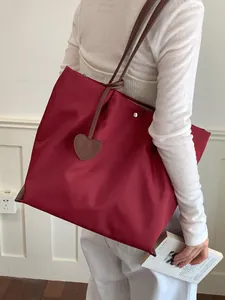 Sac fourre-tout minimaliste en nylon rouge pour femme, idéal pour le quotidien.