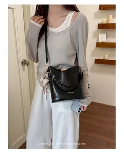 Elegant black bucket bag styled for a sophisticated retro commuter vibe with bow