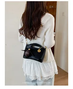 Black minimalist retro crossbody handbag for women shown in a lifestyle detail view