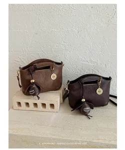 Detail of two retro women's shoulder bags in brown and dark brown leather.