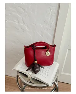 Chic red retro shoulder bag detail with elegant fashion charm on white wall background