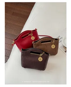 Close-up of minimalist leather crossbody bags in red, brown, and dark coffee with gold charms