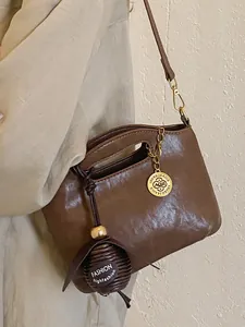 Vintage brown leather shoulder bag with circular charm and ball ornament detail