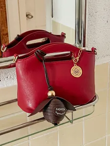 Elegant red PU leather handbag with gold hardware and decorative charms for women