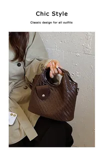 Vista detallada de un elegante bolso tipo cubo tejido marrón oscuro para estilo chic