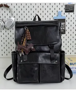 Détail d'un sac à dos en similicuir noir vintage avec porte-clés teckel et chocolat mignons