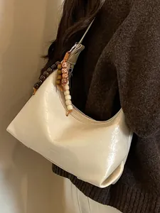 Elegante cremefarbene Hobo-Schultertasche mit Vintage-Holzperlen-Anhängern