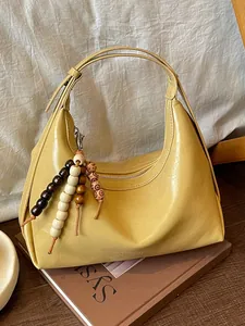 Modische gelbe Schultertasche in Halbmondform mit dekorativen Holzperlen für Damen