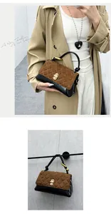 Detailed view of a brown and black quilted leather handbag with gold-tone hardware.