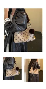 Details of chic polka dot bucket bag with unique wooden bead handle and fur pom-pom charm