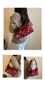 Detailed view of burgundy polka-dot shoulder bag featuring wooden bead strap