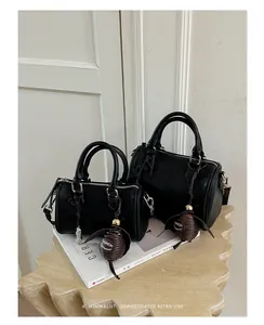 Vue détaillée des sacs à main Boston noirs rétro avec breloques de mode sur décor