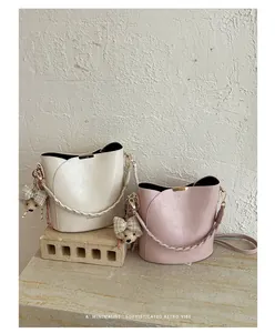 High-end minimalist bucket bags in cream and pink, featuring a sophisticated retro vibe.