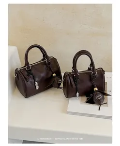 Sacs Boston marrons rétro en deux tailles sur un décor blanc minimaliste élégant