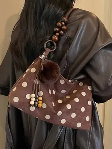 Chic brown polka dot shoulder bag with wooden bead strap and fur pom pom charm