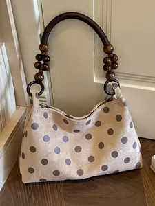 Stylish polka dot shoulder bag with unique wooden bead handle detail