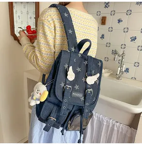 Retro-Jeans-Rucksack mit Sternenmuster und niedlichen Flügelanhängern in Lifestyle-Umgebung