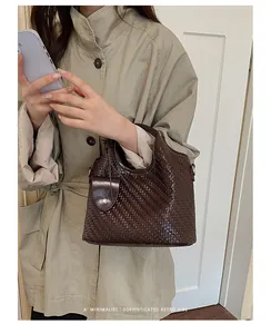 Bolso bombonera de cuero trenzado marrón para mujer con un aire retro minimalista