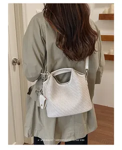 Vista trasera de una modelo con bolso de cubo tejido blanco para estilo elegante
