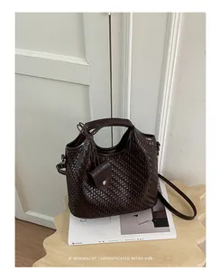Primer plano de un bolso bombonera de tejido marrón oscuro sobre una revista minimalista.